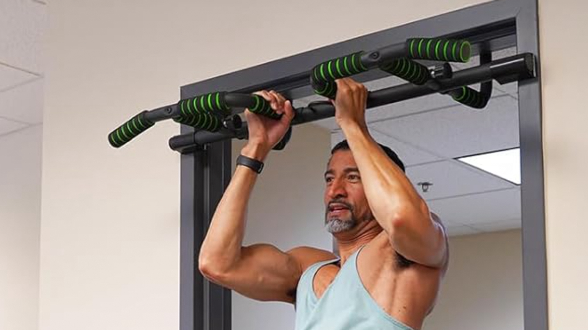 The Kakiclay Foldable Design Pull-Up Bar being used by a man in a doorway